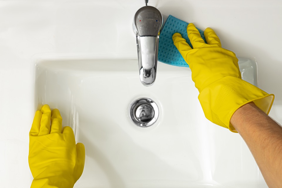 Cleaning a bathroom sink and faucet by hand